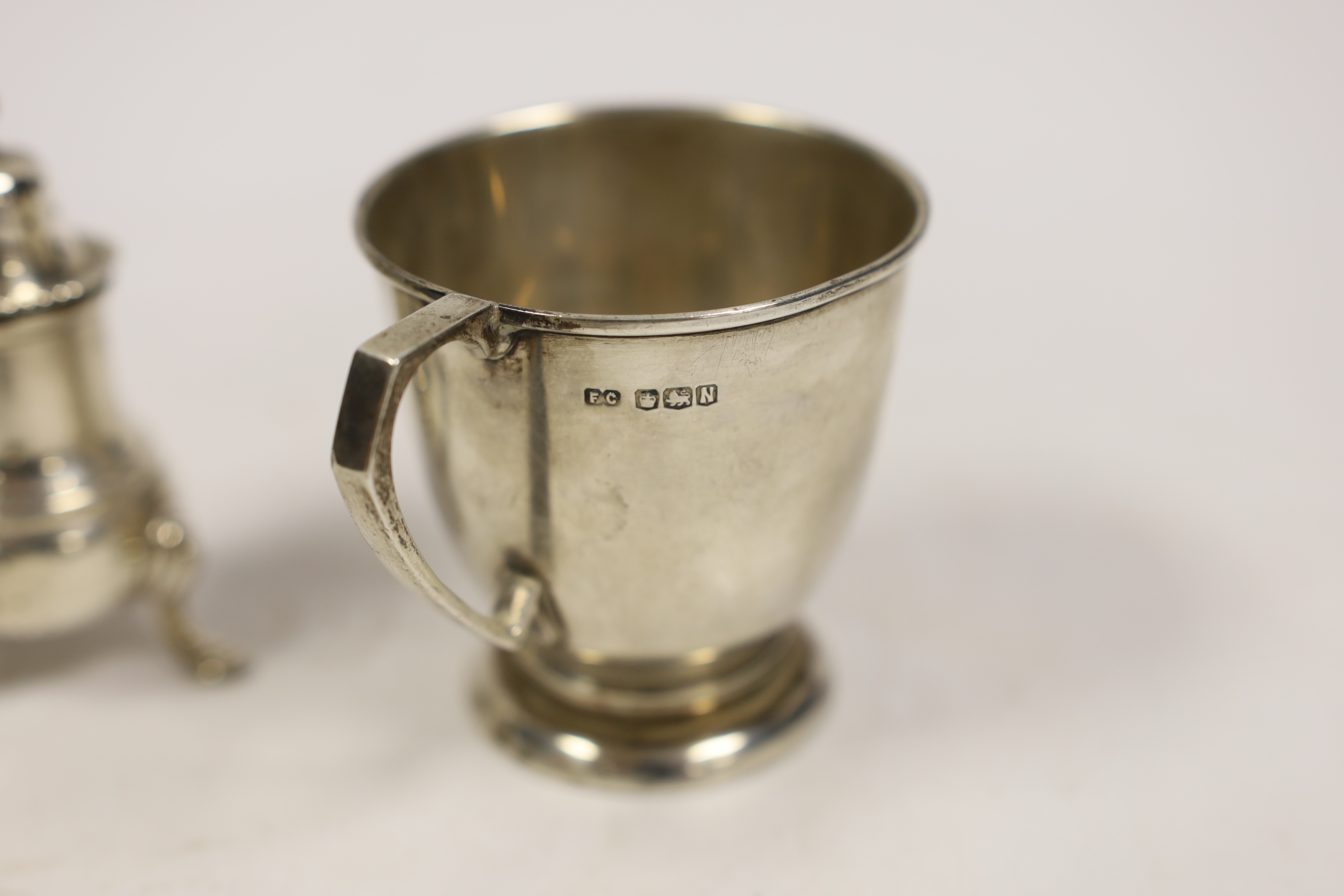 A 1950's silver christening mug, 70mm and a similar silver three piece condiment set.